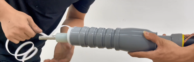 Worker installing cold shrink cable termination on medium voltage cable